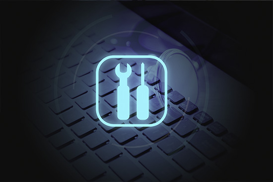 Wrench and screwdriver blue icon floating over a keyboard