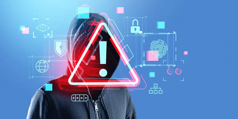 A person with a hooded sweatshirt on with a glowing cybersecurity icon covering his face